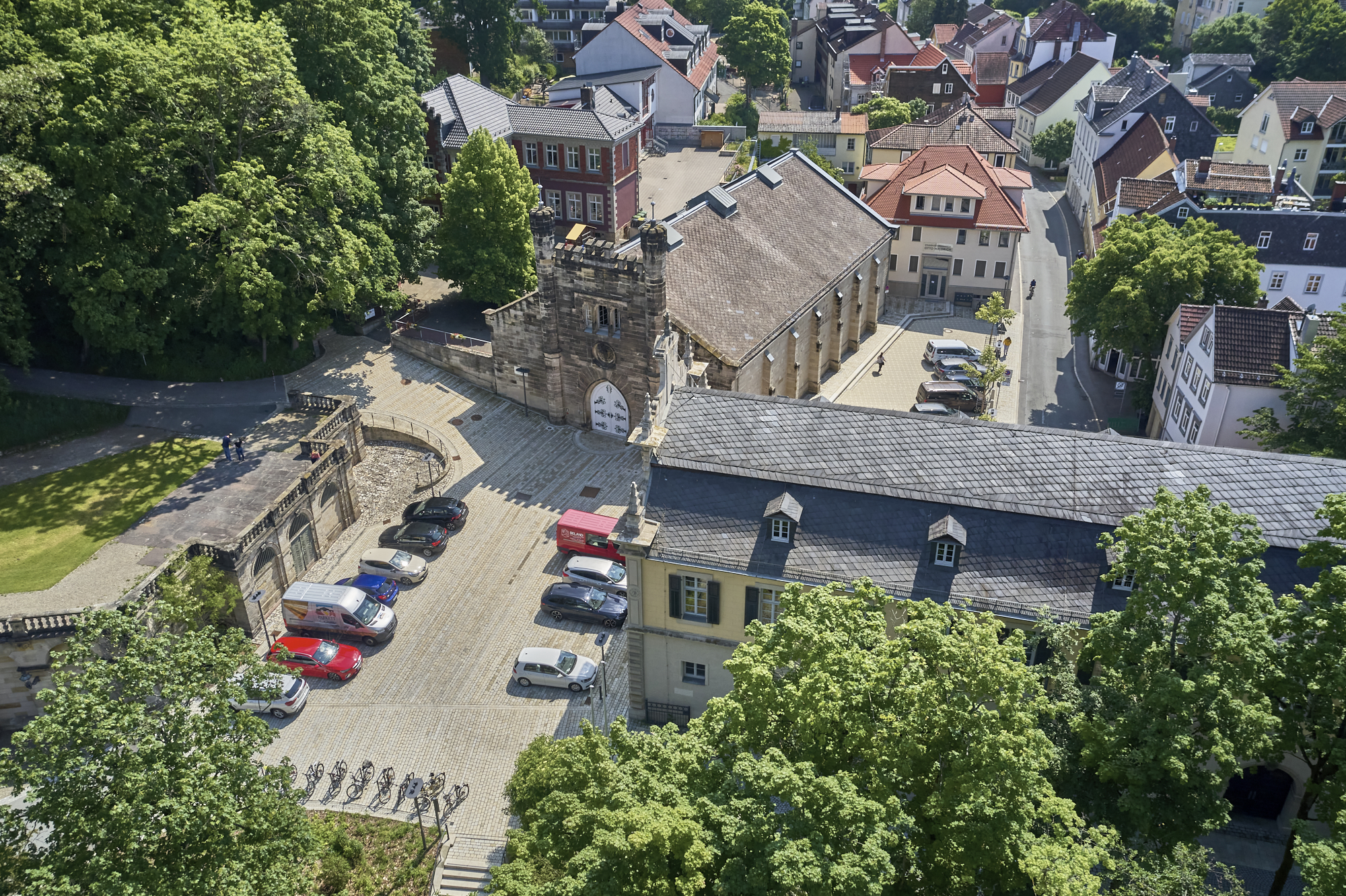 Luftaufnahme Gebäude mit davor liegendem Parkplatz.