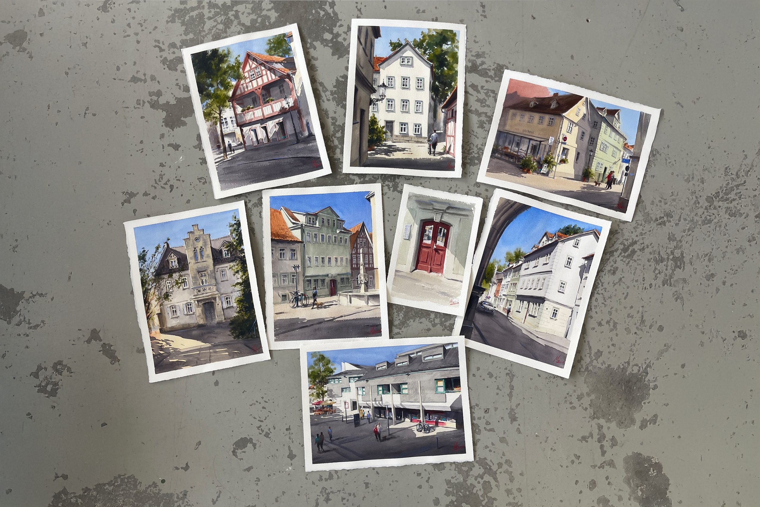 Betonboden mit Aquarellgemälden von verschiedenen Gebäuden.