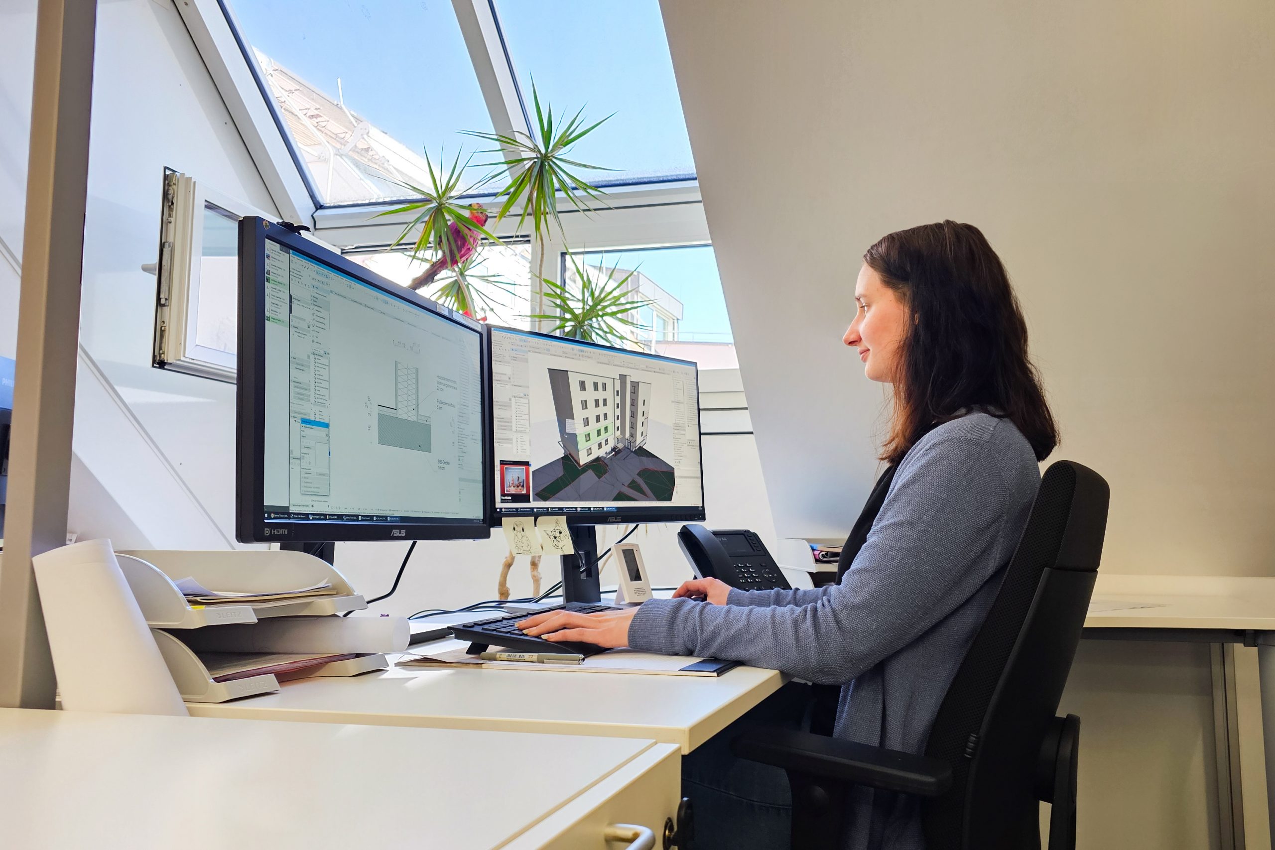 Bauzeichner_in Bauzeichnerin die am Computersitzt und in einem CAD Programm arbeitet.