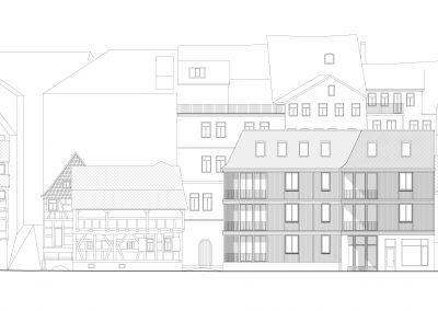 Eine technische Architekturzeichnung, die eine Häuserzeile in einer Stadt darstellt; ein Gebäude im rechten Drittel ist dabei dunkel hervorgehoben.