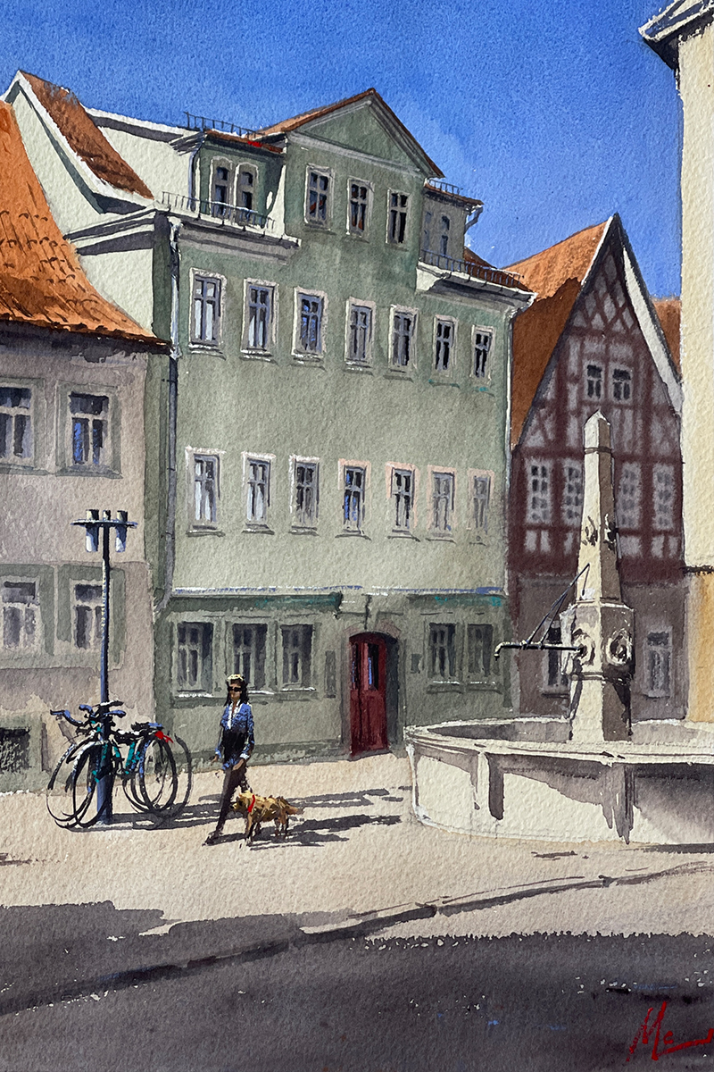 Aquarellgemälde eines grünen Gebäudes mit roter Eingangstür. Vor dem Gebäude steht ein Brunnen. 