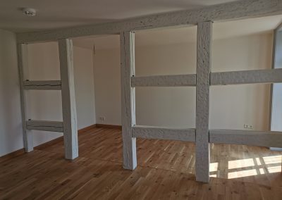 Innenraum mit weiß gestrichenem Fachwerk.