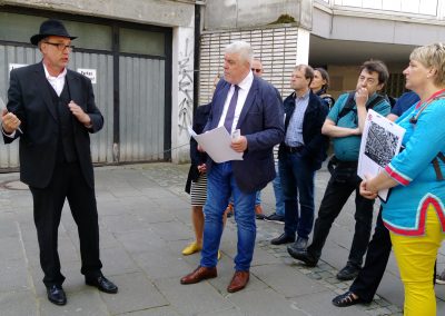 Gruppe mit Stadtführer vor alten Gebäuden