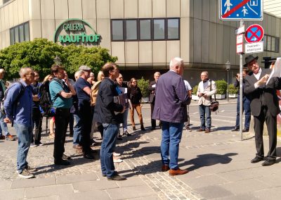 Gruppe mit Stadtführer vor einem Einkaufszentrum