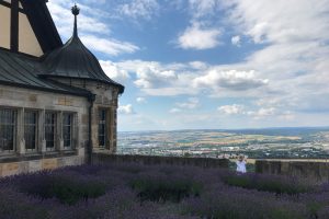 Lavendel-Feld in dem ein Kind steht, das auf eine Stadt herab schaut.