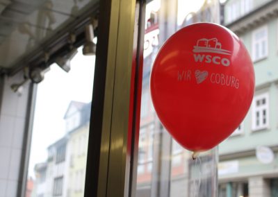 Roter Luftballon mit dem Wohnbau Logo und der Aufschrift