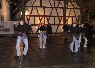 Tanzgruppe vor beleuchtetem Gebäude